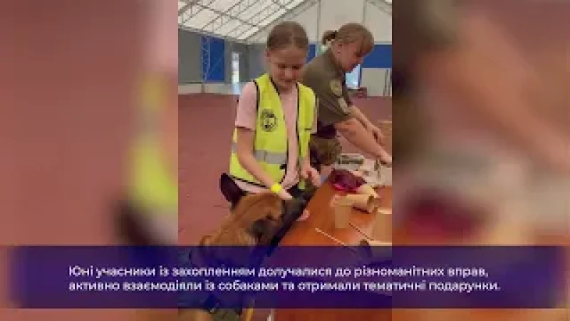 На фотографії зображено кінологиню поліції Київщини Катерину Бєляєву, яка провела захід для діток захисників столиці у Кінологічному центрі. Юні учасники із захопленням долучалися до різноманітних вправ, активно взаємодіяли із собаками та отримали тематичні подарунки.
