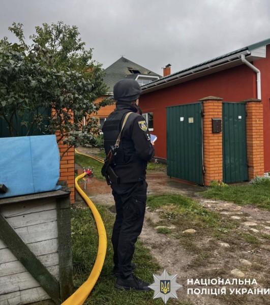 На фото зображено поліцейського, який документує наслідки ворожої атаки.