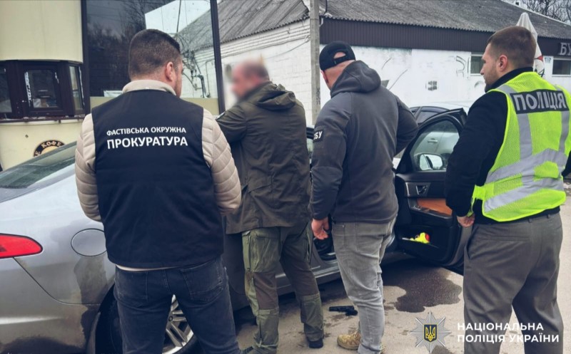 На фото затриманий зловмисник та працівники поліції.