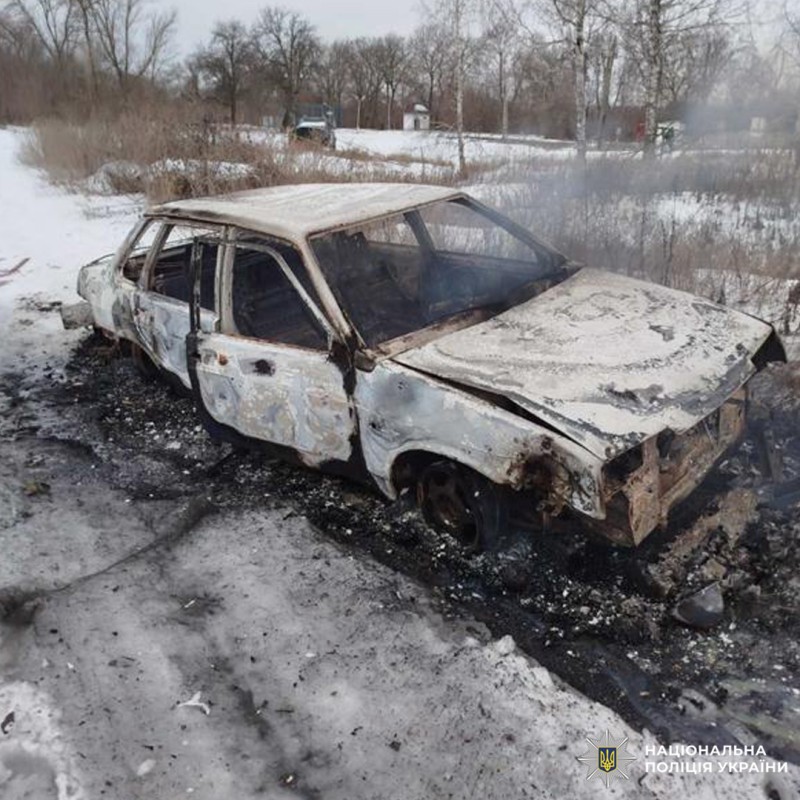 Повністю знищений вогнем автомобіль стоїть на засніженому узбіччі, навколо видно сліди пожежі.