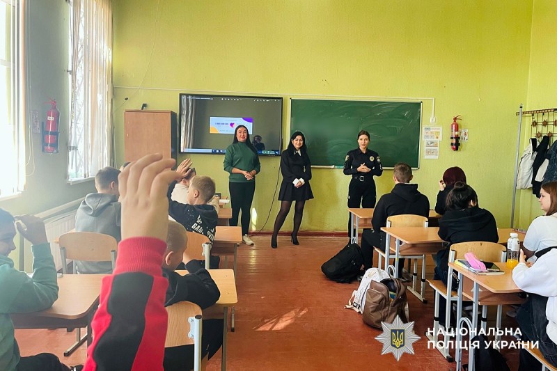 Поліцейська у класі говорить з учнями на тему безпеки