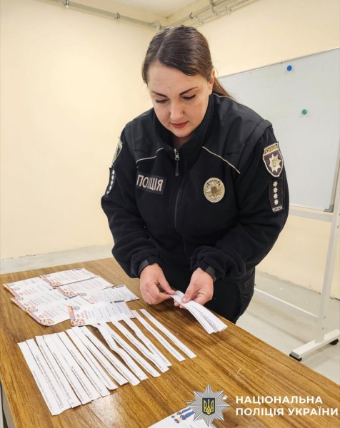 На фото зображена інспекторка, яка готує матерілаи для проведення заходу.