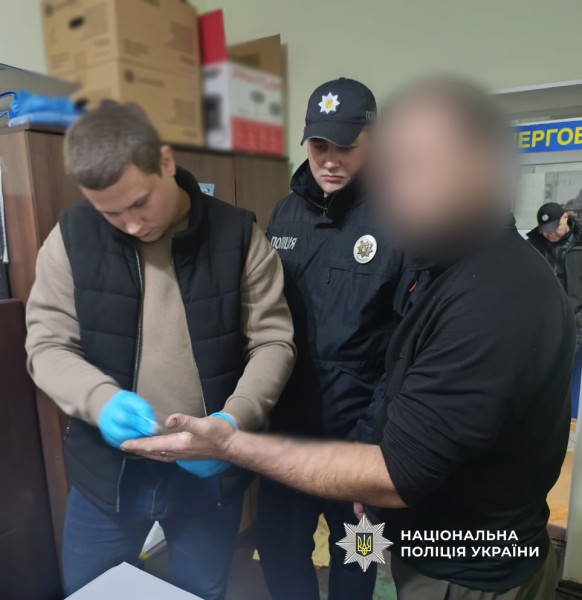 поліцейські беруть відбитки пальців у правопорушника
