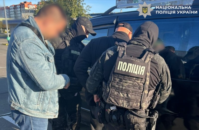 На фотографії зображено поліцейських та зловмисника, якому повідомлено про підозру за фактом одержання неправомірної вигоди.