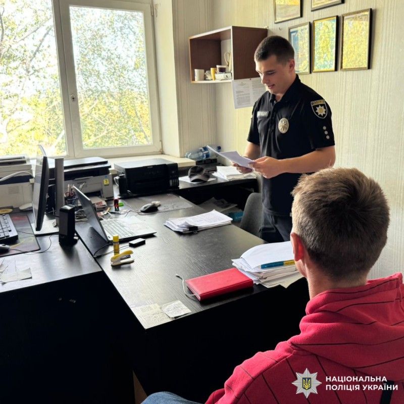 Поліцейська веде розмову з затриманим у кабінеті відділку поліції.