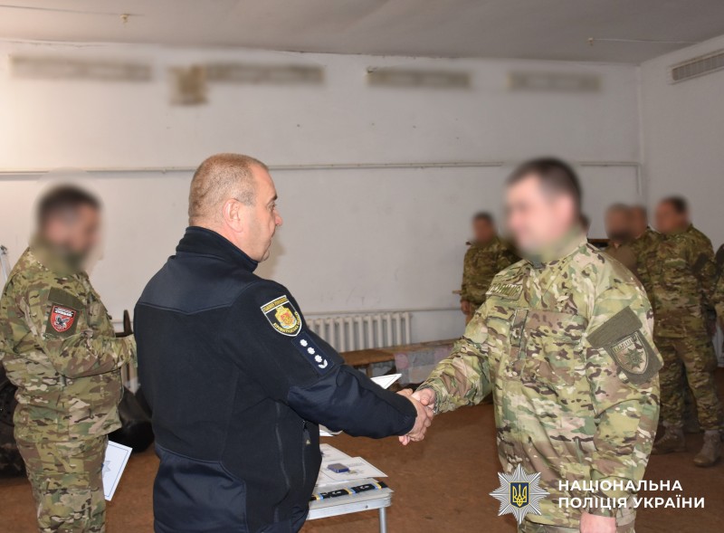 керівник поліції області вручає нагороду поліцейському