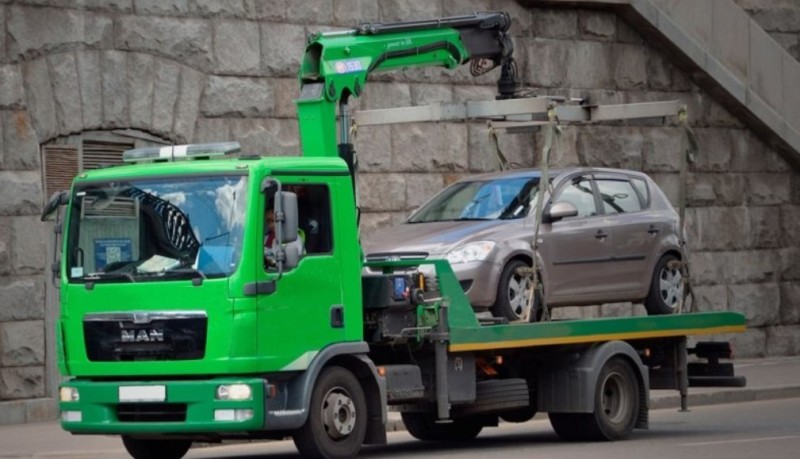 На фото зображений евакуатор та автомобіль, який він евакуює.
