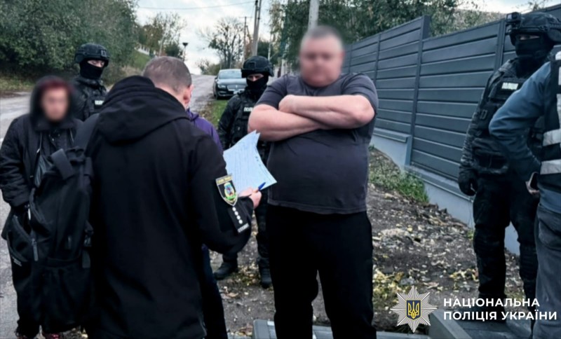 На фото один з фігурантів та правоохоронці.