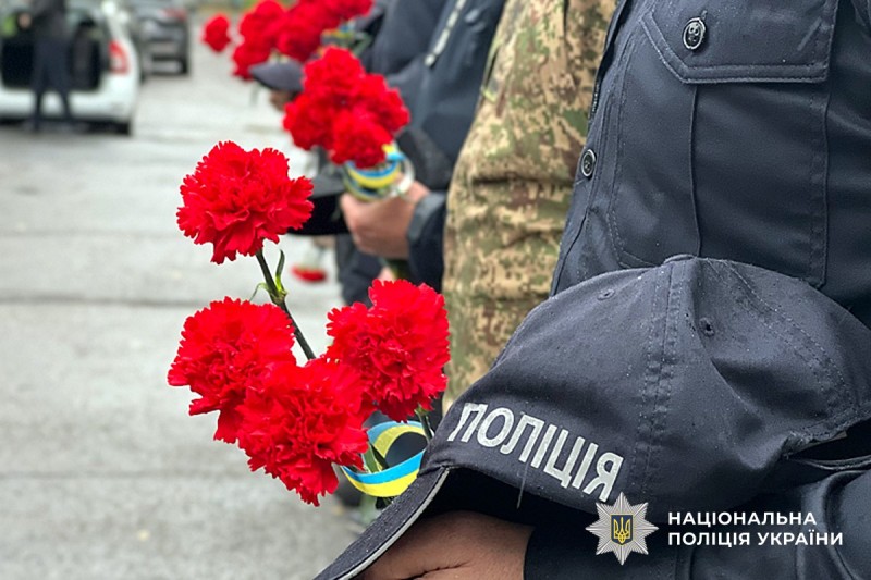 Квіти для вшанування тримає поліцейський