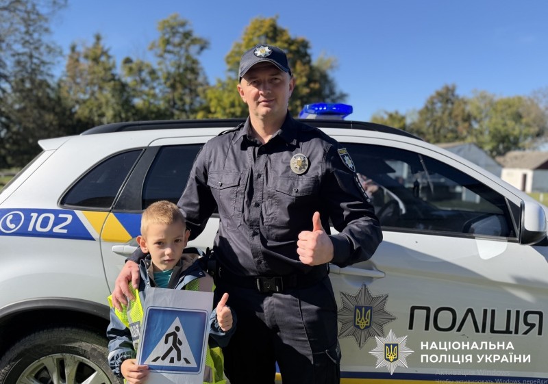 поліцейський з дитиною на зустрічі з правил дорожнього руху