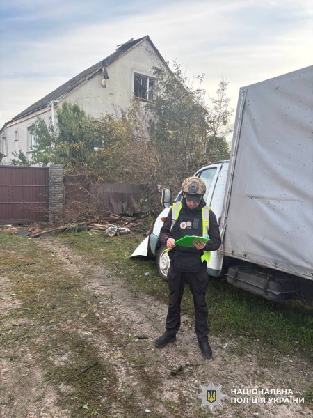 На фотографії зображено поліцейського Київщини, який документує наслідки ворожої атаки.