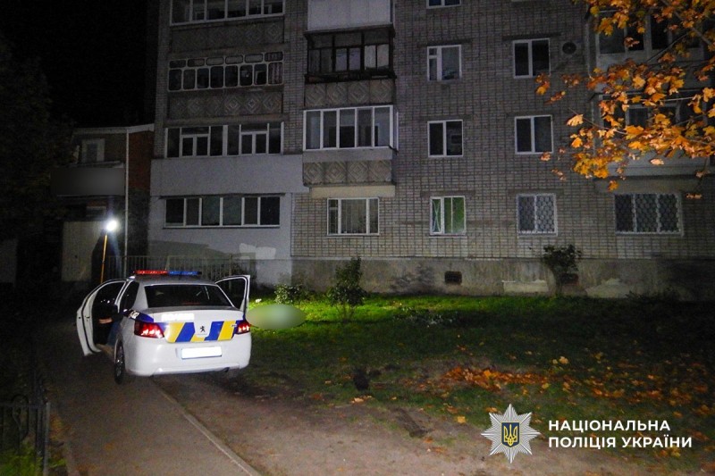 Автомобіль поліції та будинок, поряд з яким виявили тіло чоловіка