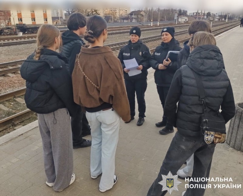 На фотографії зображено поліцейських Київщини, які проводять профілактичні заходи з підлітками на залізниці.
