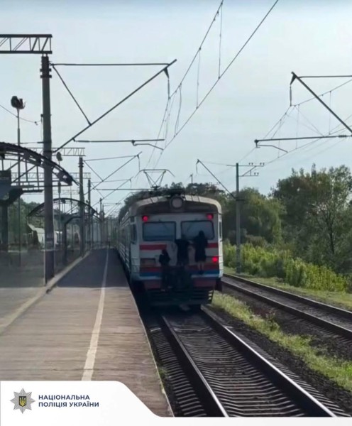 На фотогрфії зображено залізницю та транспорт, де діти займаються зачепінгом.