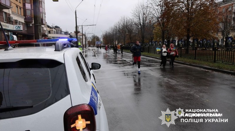 поліцейське авто на фоні забігу