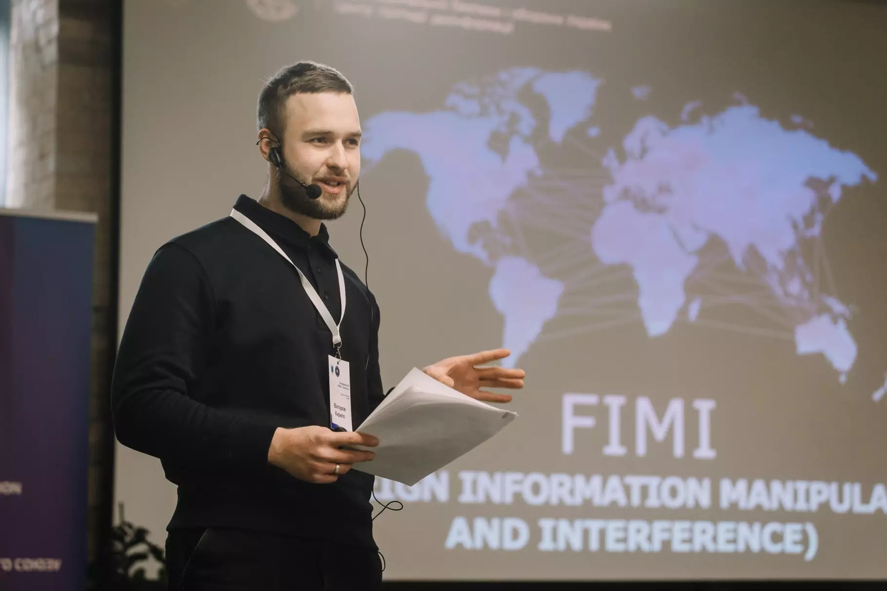 Спікер конференції Кирило Вікторов на фоні екрана з презентацією