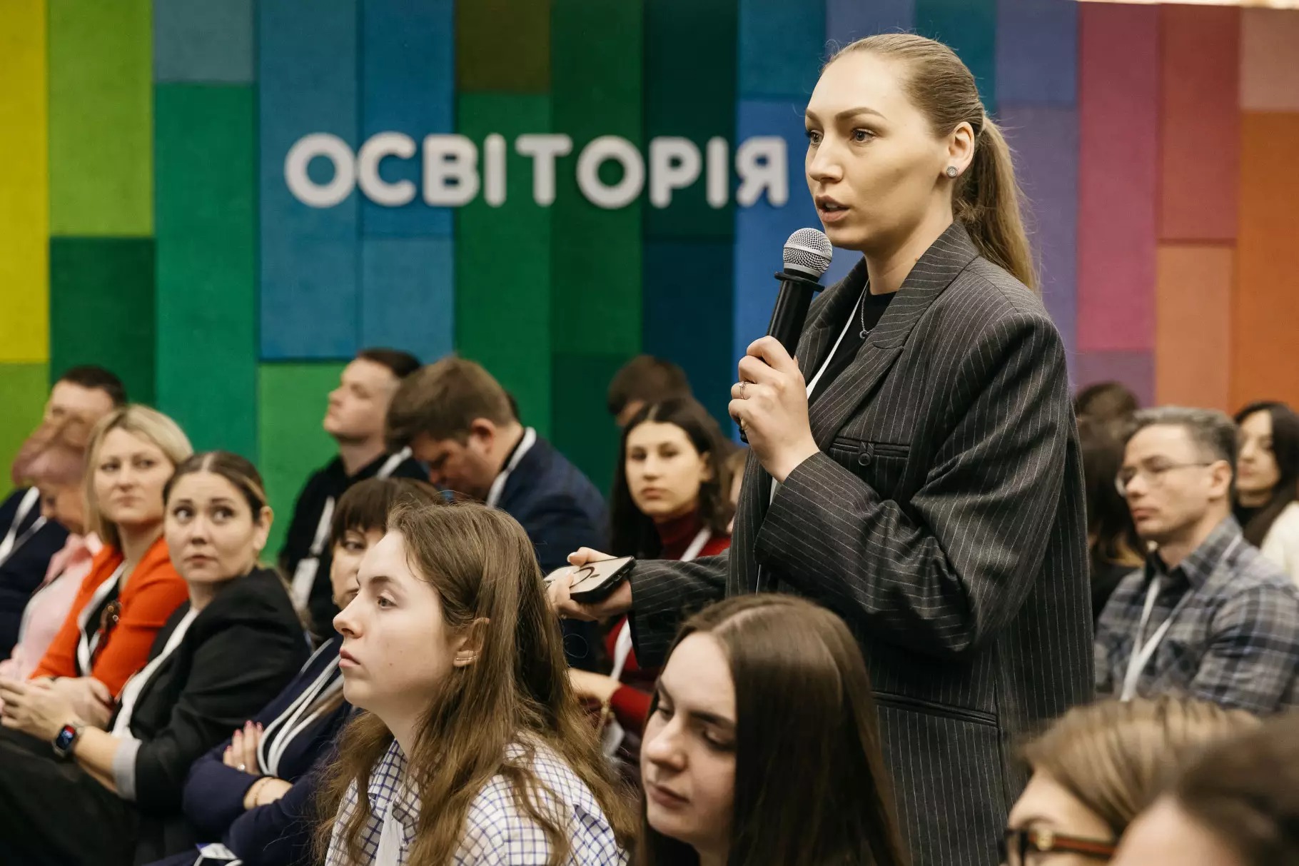 Учасниця конференції задає питання спікеру