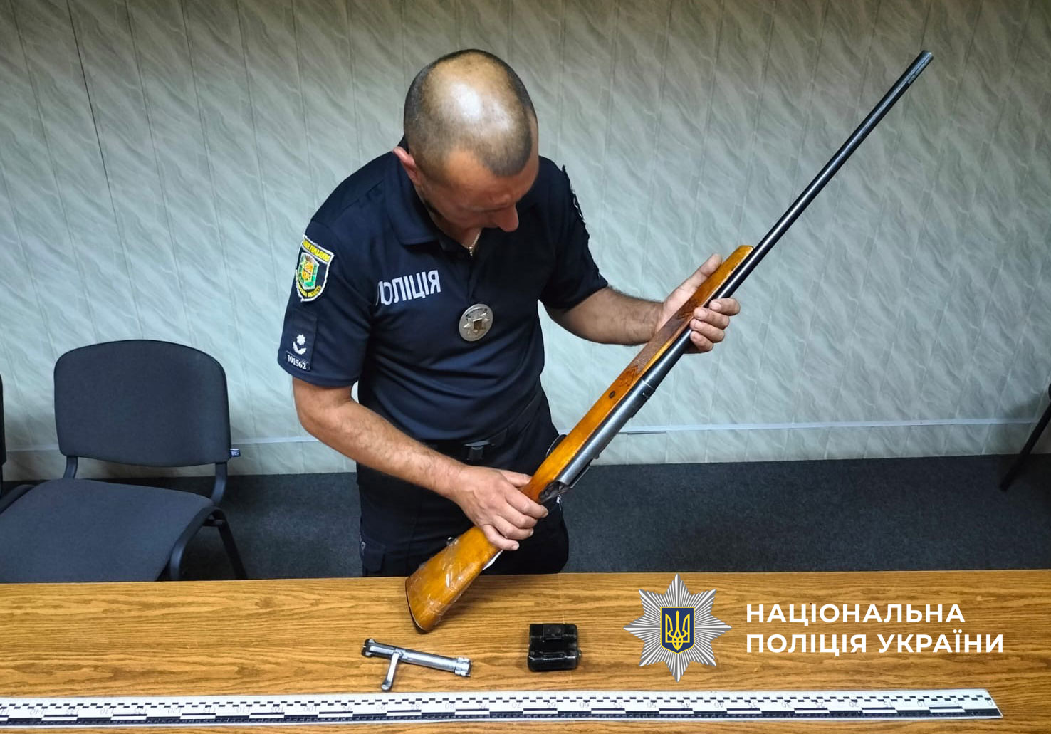 Поліцейський проводить огляд добровільно зданої зброї 