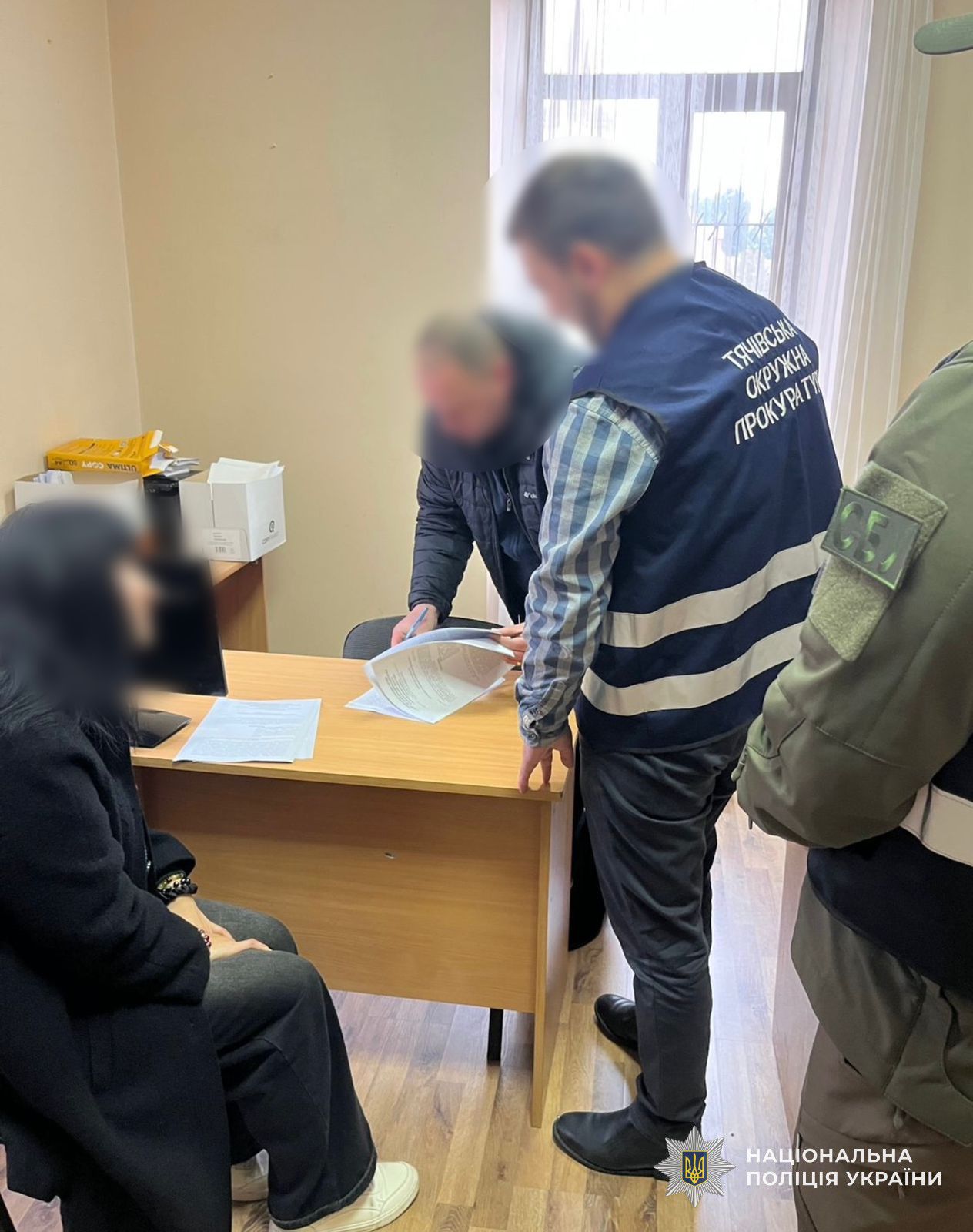 фігурантка з правоохороцями під час вручення їй підозри