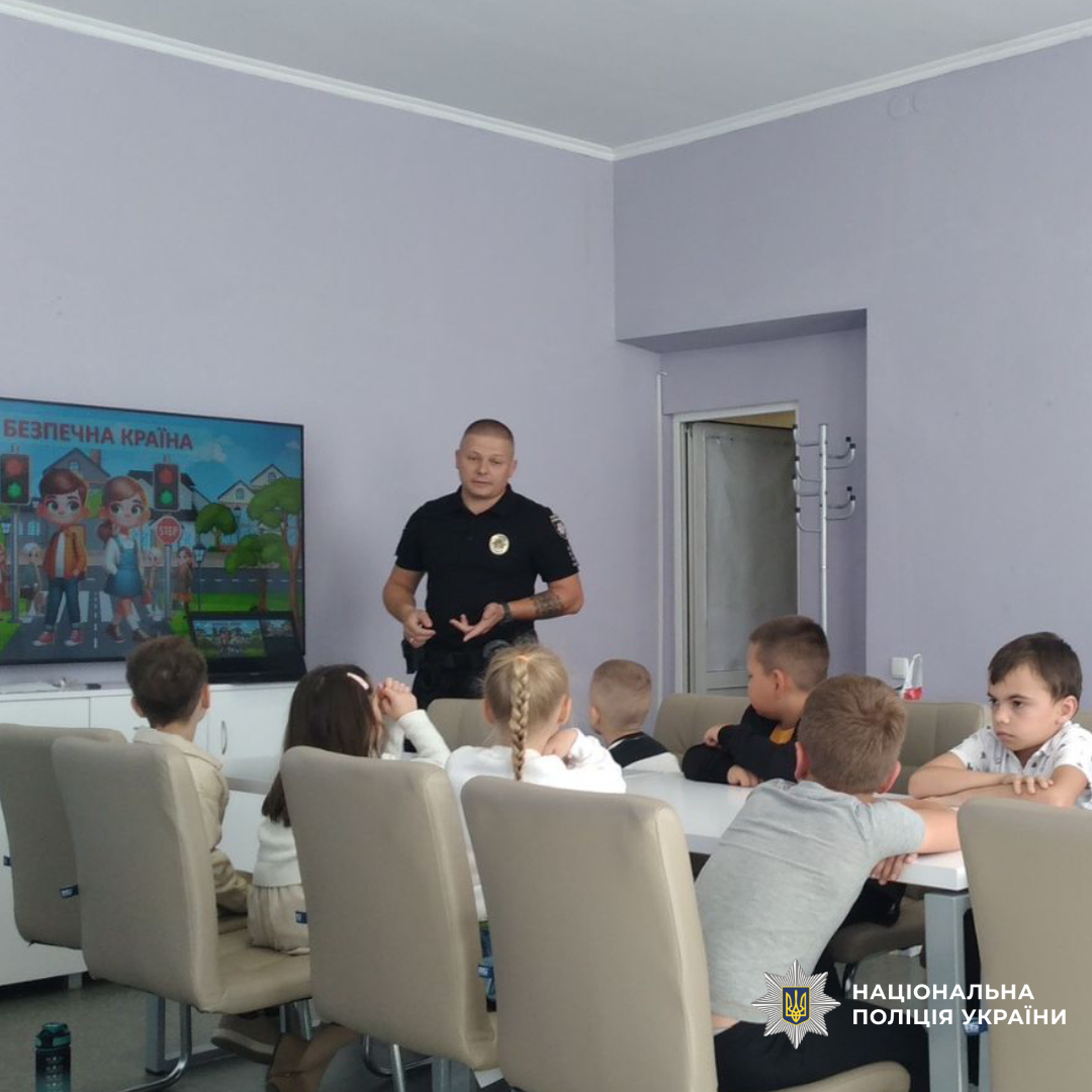 Поліцейський проводе захід для дітей у приміщенні