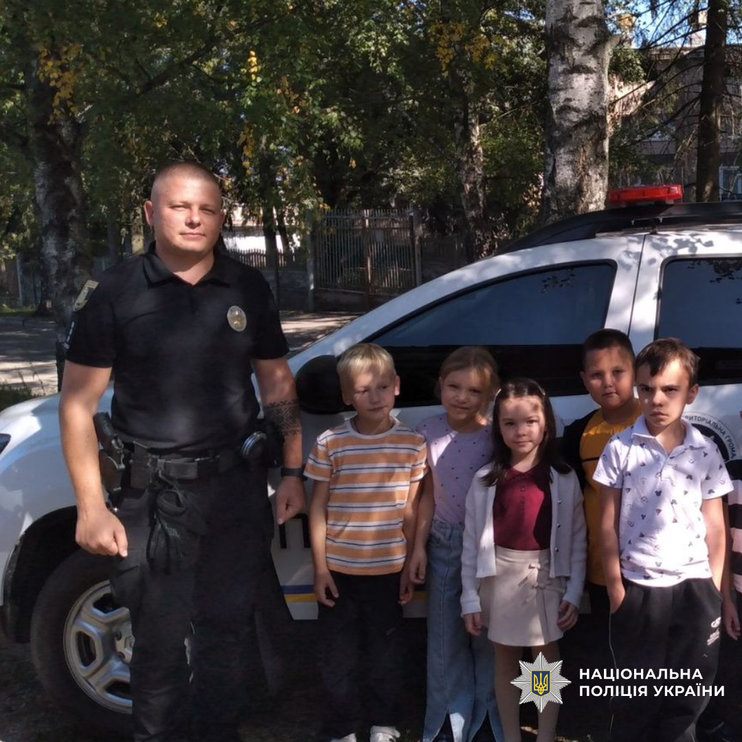 Поліцейський разом з дітми біля поліцейської машини