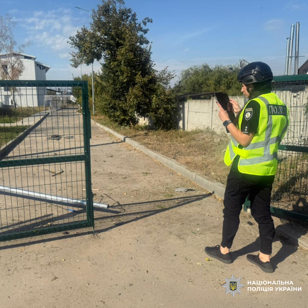 Поліцейська фотографує руйнування в наслідок обстрілу