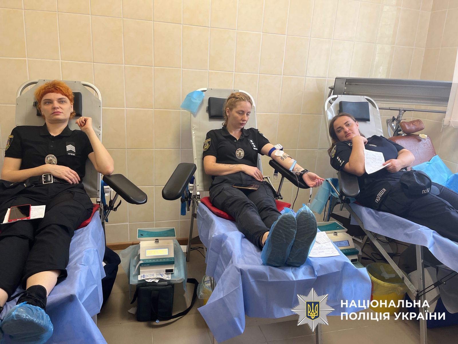 На фото зображені три поліцейські, у спеціальних кріслах та здають кров.