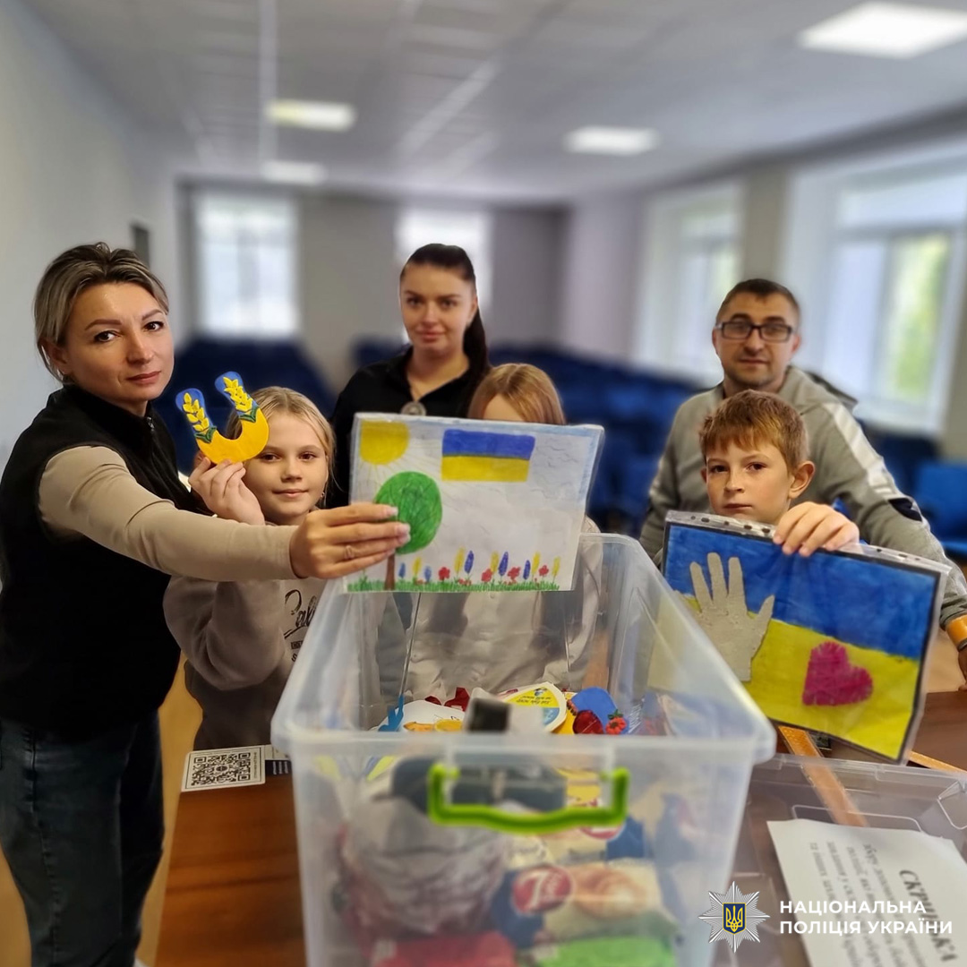 Люди, зокрема діти, тримають дитячі вироби з українською символікою.