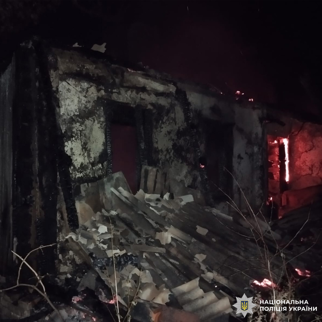 Згорівша будівля вночі, обвалений дах, навколо обвуглені уламки.