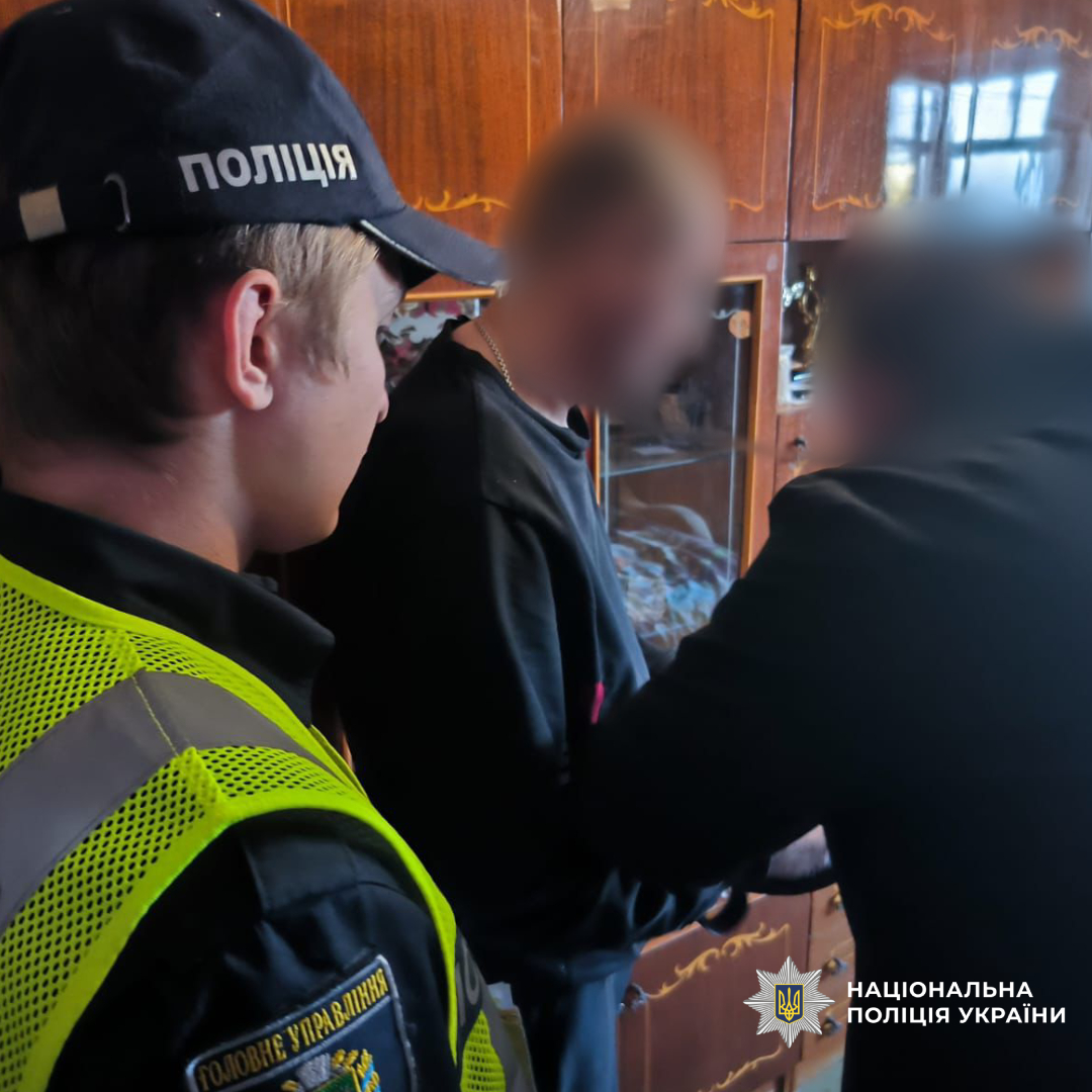 Поліцейські стоять поруч с затриманим