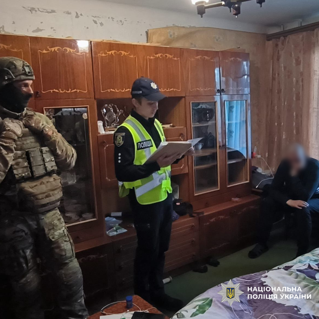 Поліцейські стоять поруч с затриманим