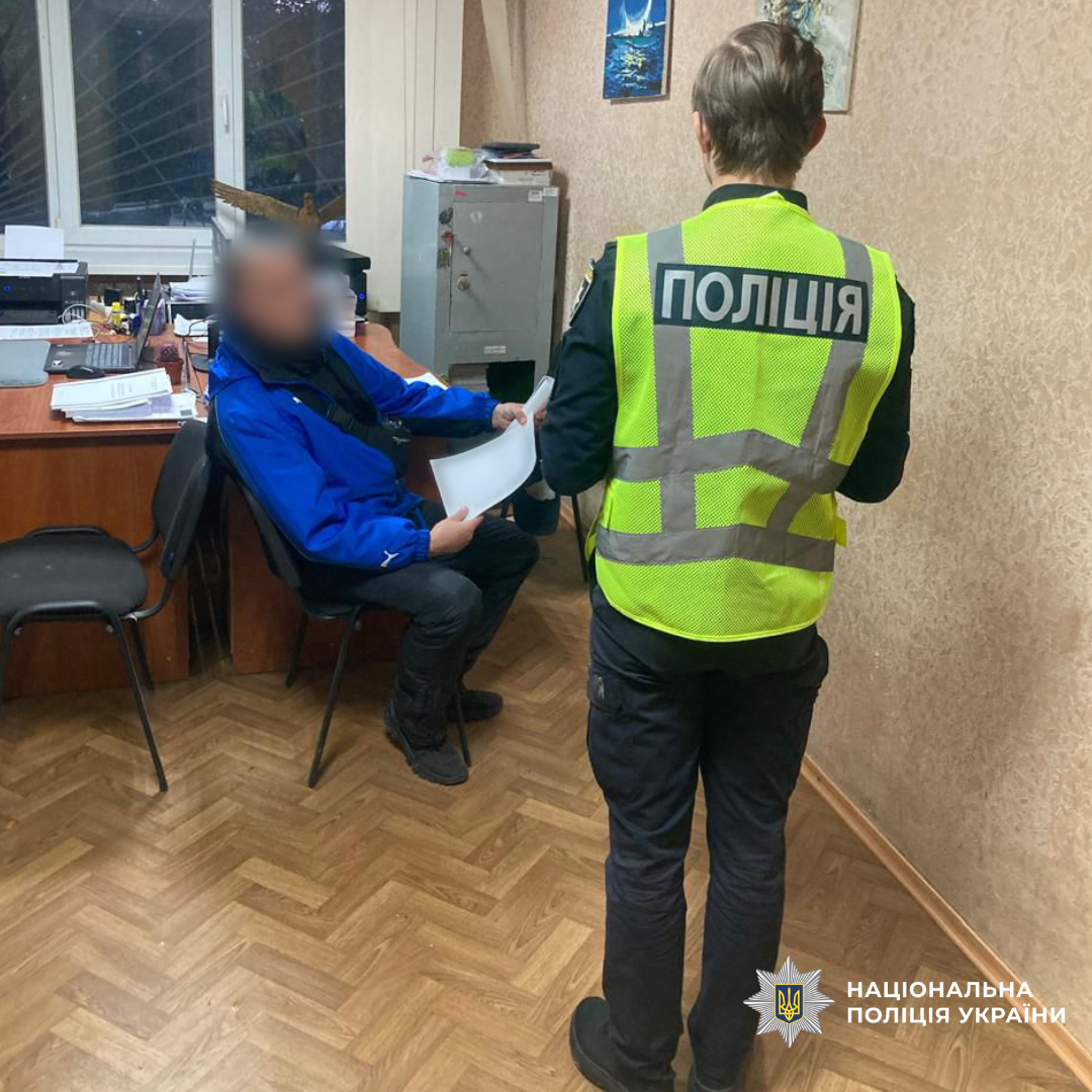 Поліцейська стоїть поруч с затриманим