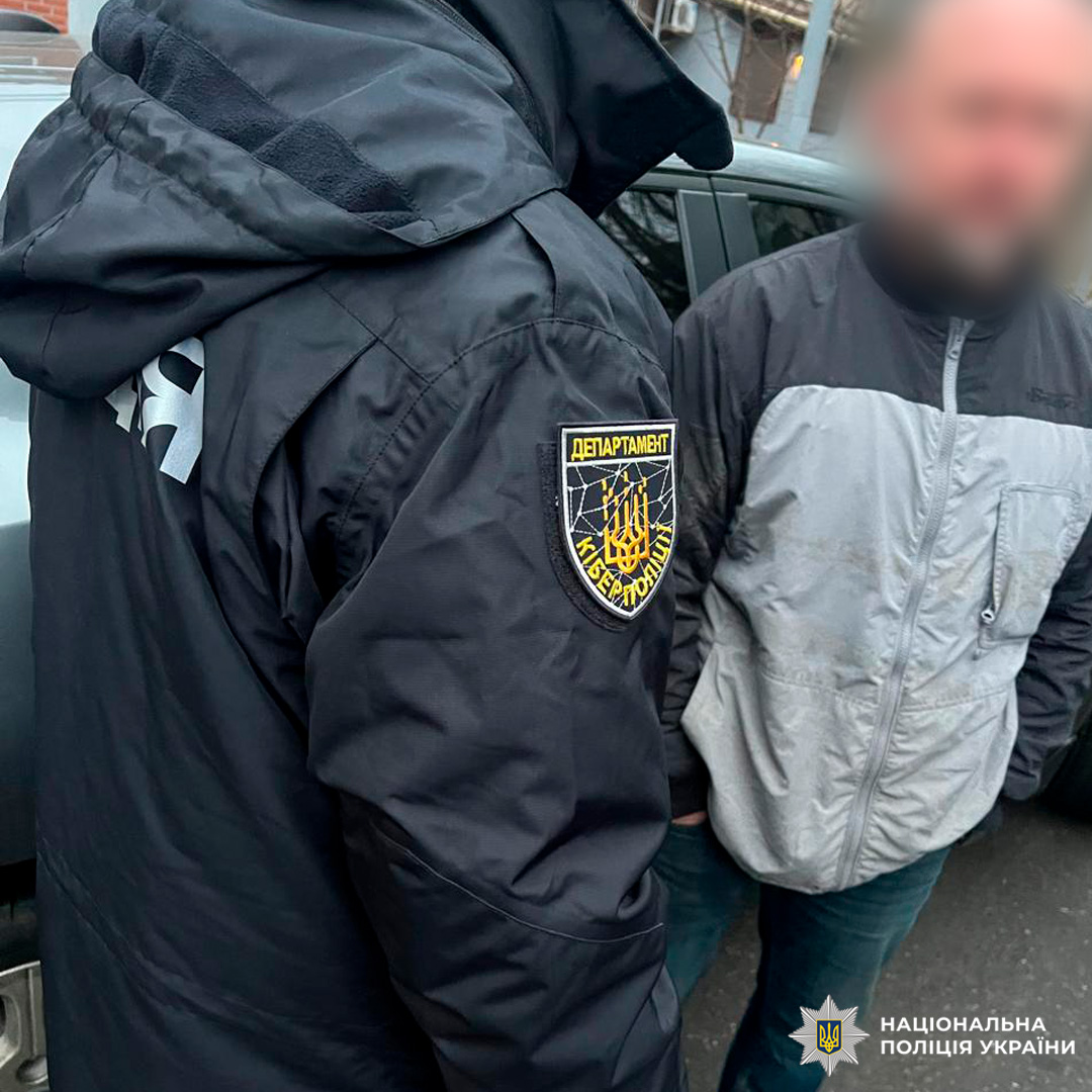 Двоє людей біля авто, один із шевроном кіберполіції України.