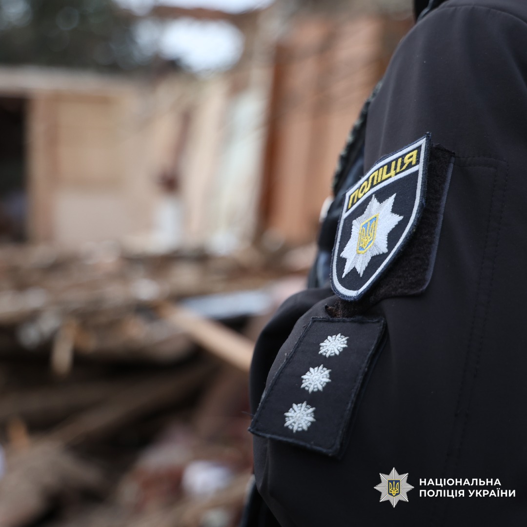 Поліцейські стоять поруч зі зруйнованими будинками