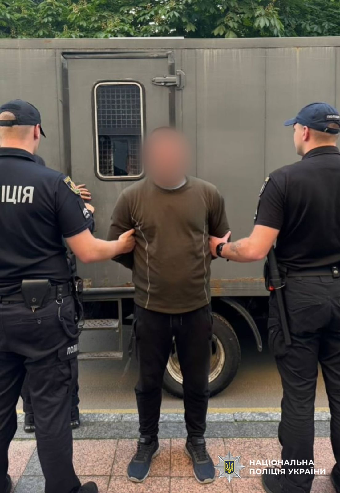 поліцейські тримають фігуранта при конвоюванні