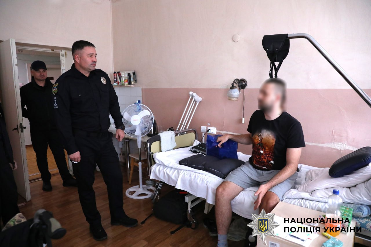 На фото зображено начальника управління кадрового забезпечення поліції Київщини, який відвідує поранених бійців.