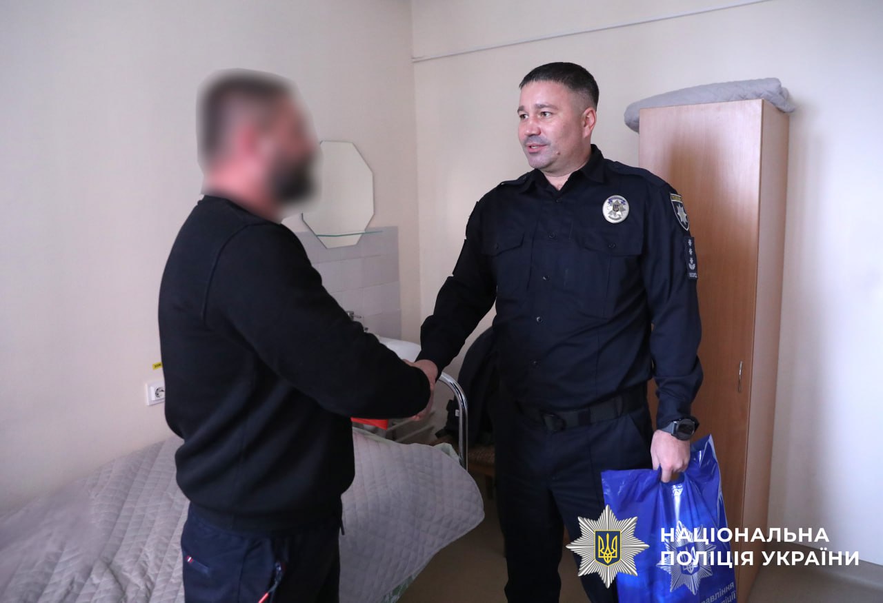 На фото зображено начальника управління кадрового забезпечення поліції Київщини, який відвідує поранених бійців.
