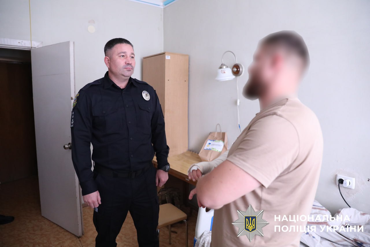 На фото зображено начальника управління кадрового забезпечення поліції Київщини, який відвідує поранених бійців.