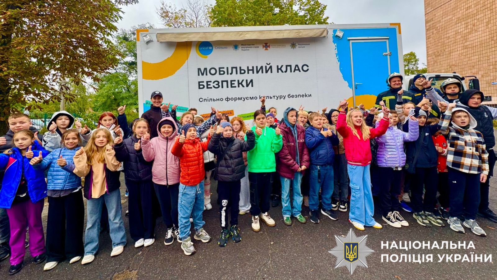 На фото забражені діти, поліцейські та працівники ДСНС, які позують для фото.