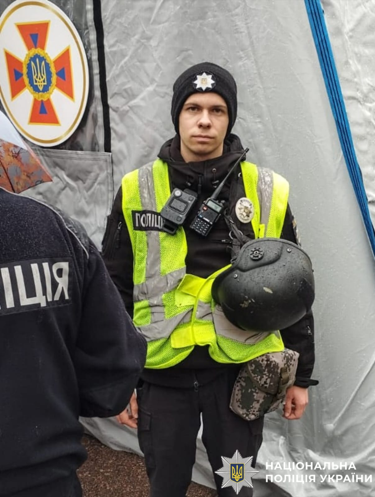 На фото зображено поліцейського, який чергує в пунктні незламності та допомагає містянам під час блекауту.