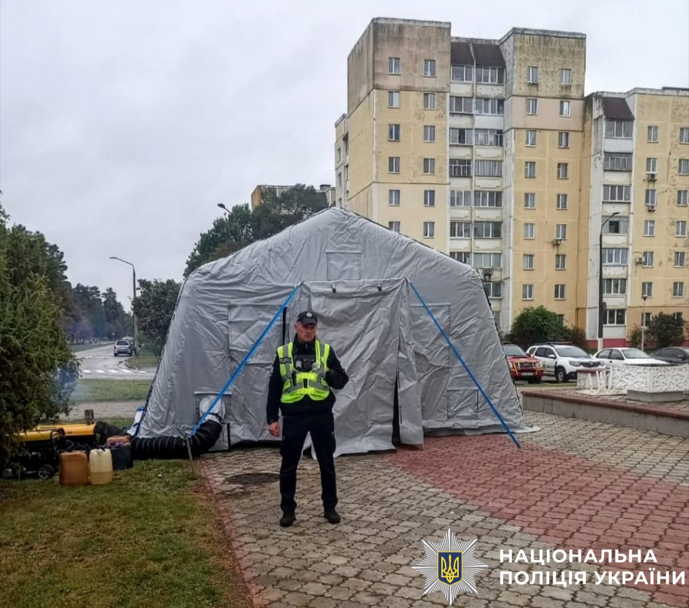 На фото зображено поліцейського, який чергує в пунктні незламності та допомагає містянам під час блекауту.