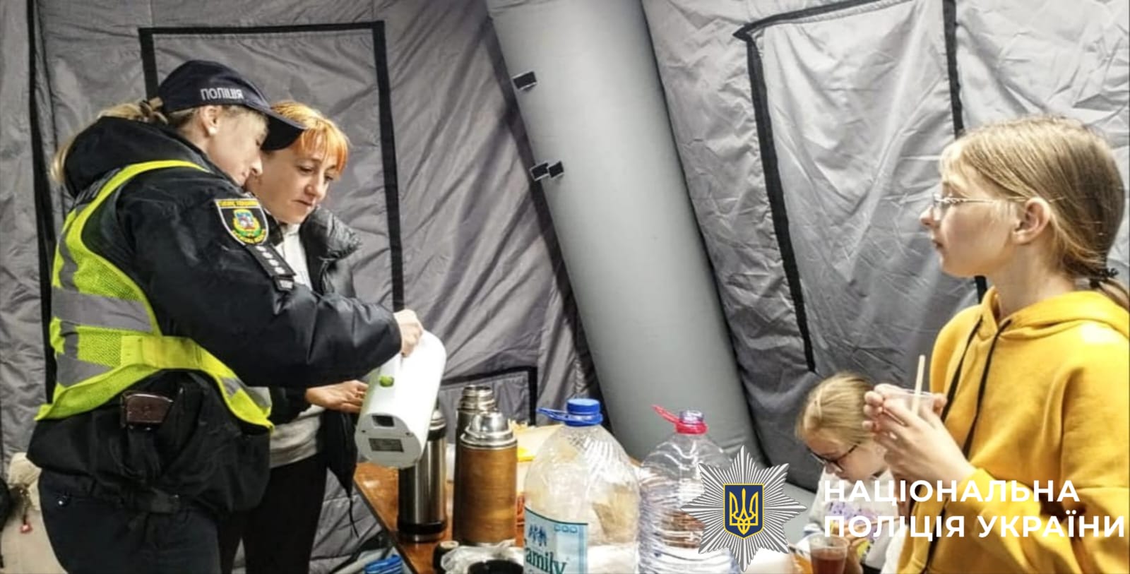На фото зображено пунктн незламності та поліцейську, яка допомагає містянам під час блекауту.