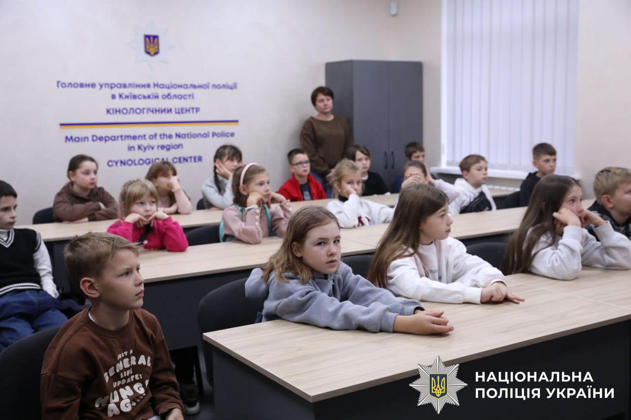 Діти сидять за столами та слухають лекцію.
