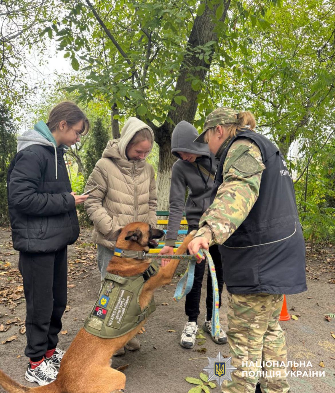 На фото зображено кінологиню поліції Київщини зі службовивими собаками та діти.
