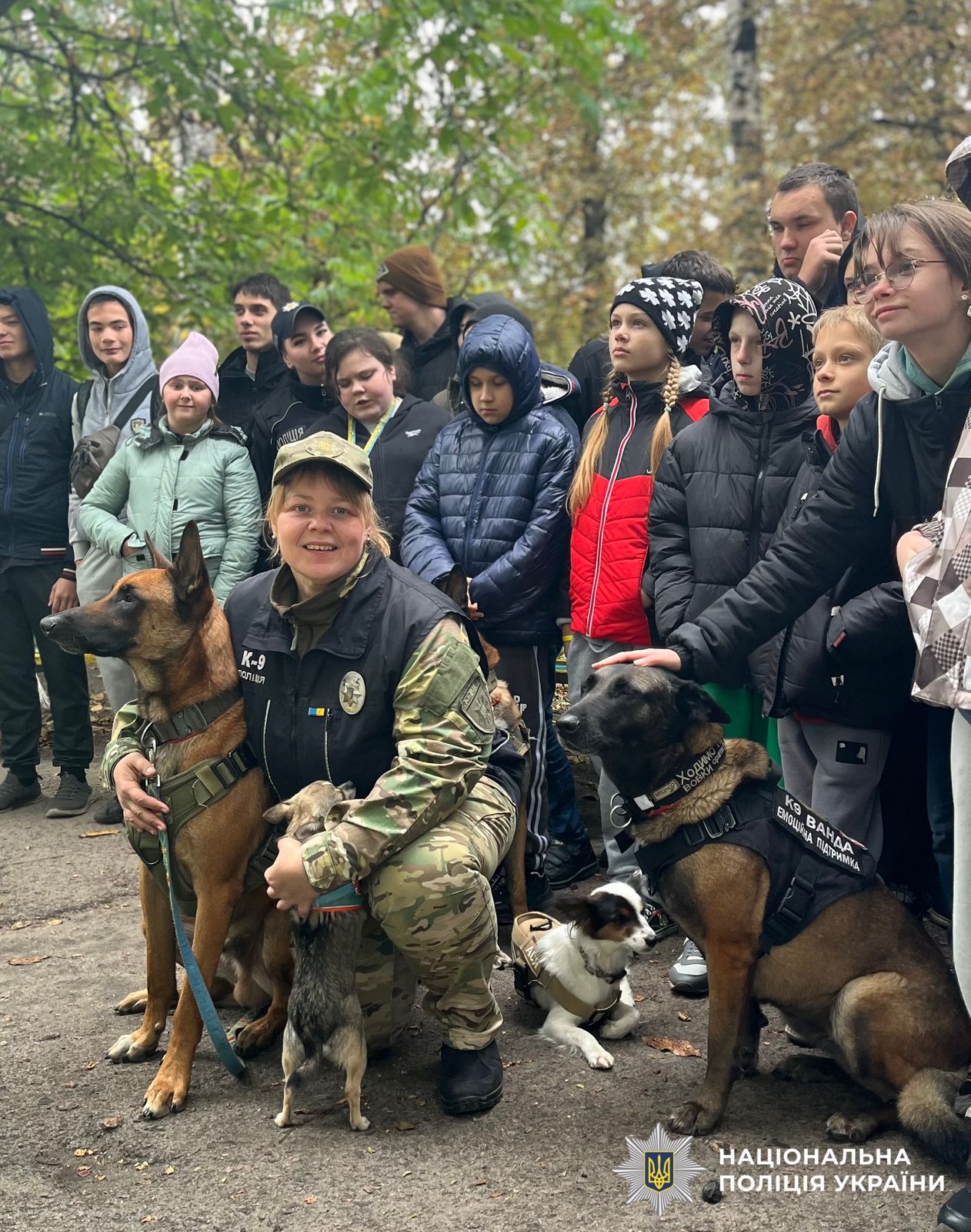 На фото зображено кінологиню поліції Київщини зі службовивими собаками та діти.