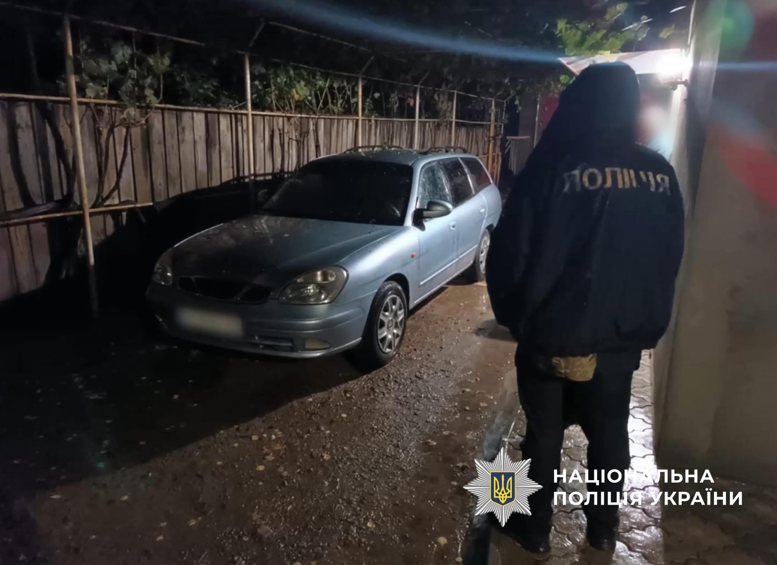 Поліцейський стоїть біля пошкодженого автомобіля господаря.
