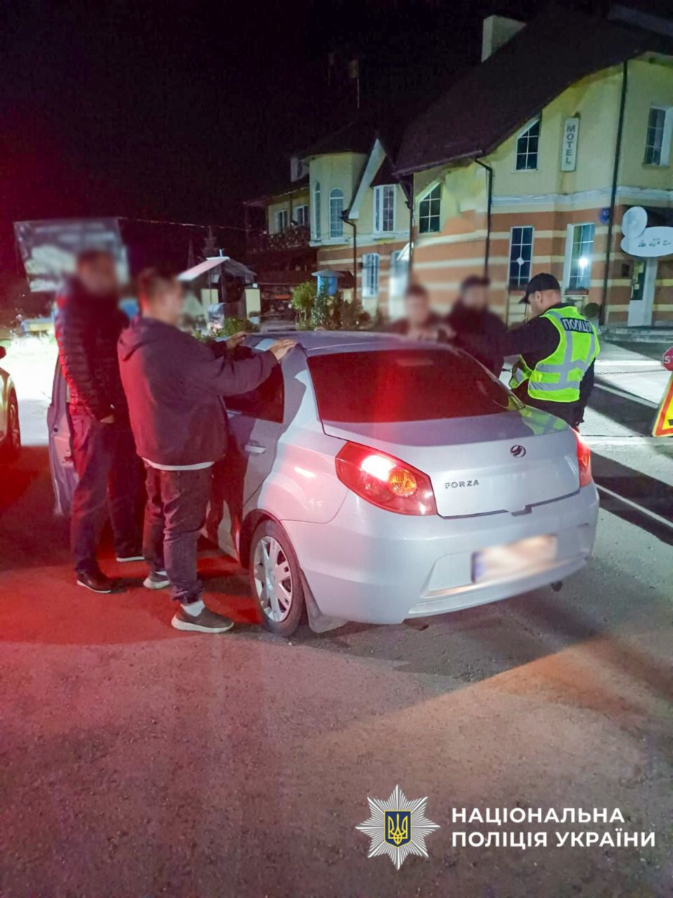 На фото автомобіль поряд з яким стоять зловмисник та поліцейські.