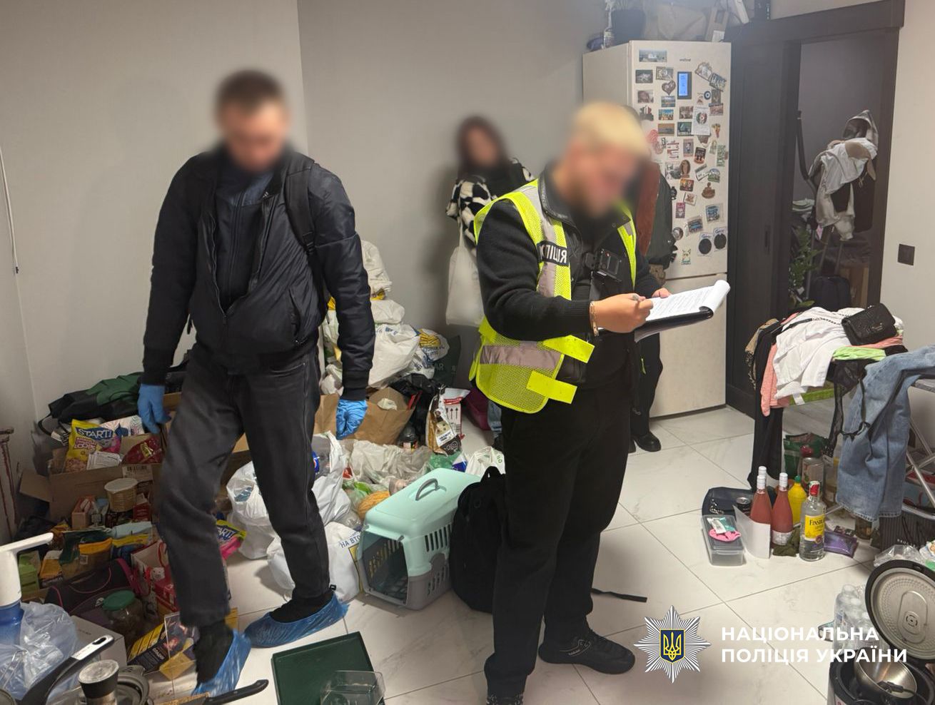 На фото зображені поліцейські, які проводять обшук у фігурантки.