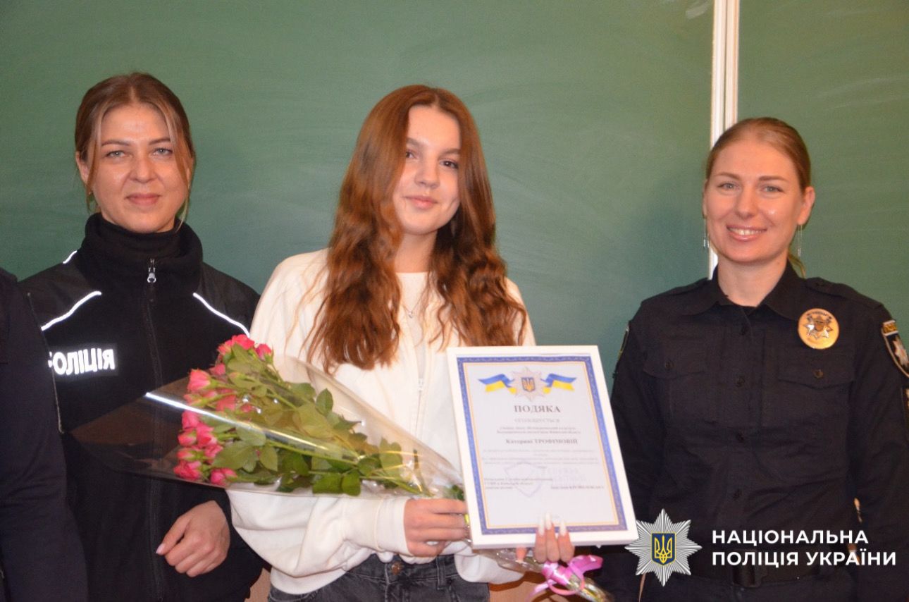 Фото нагородженої дівчини з поліцейськими.