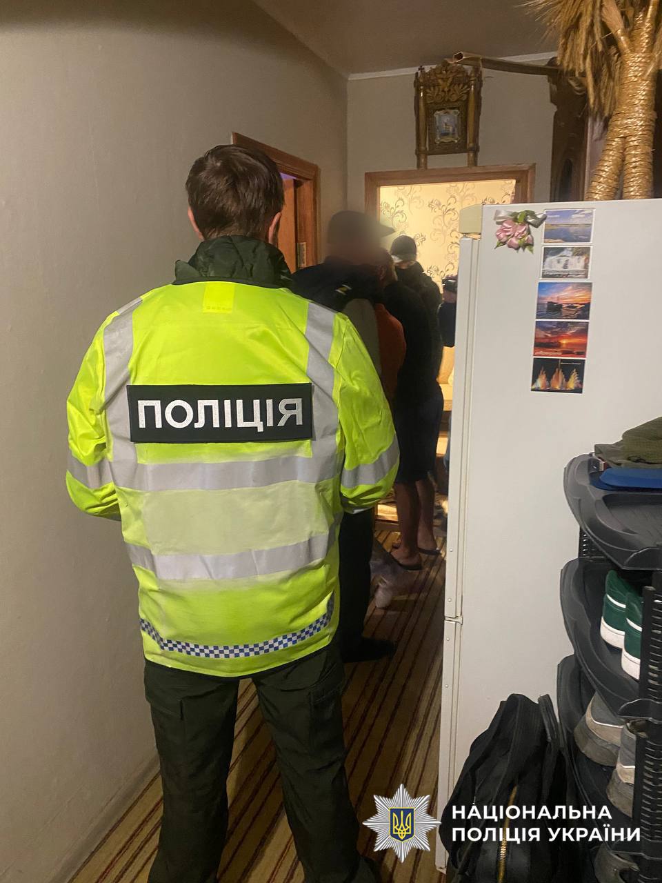 На фото поліцейський, який проводить обшук.
